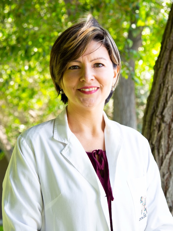 Professional female doctor in white coat smiling confidently